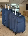Four-Piece Navy Blue Softshell Spinner Suitcase Set - 1